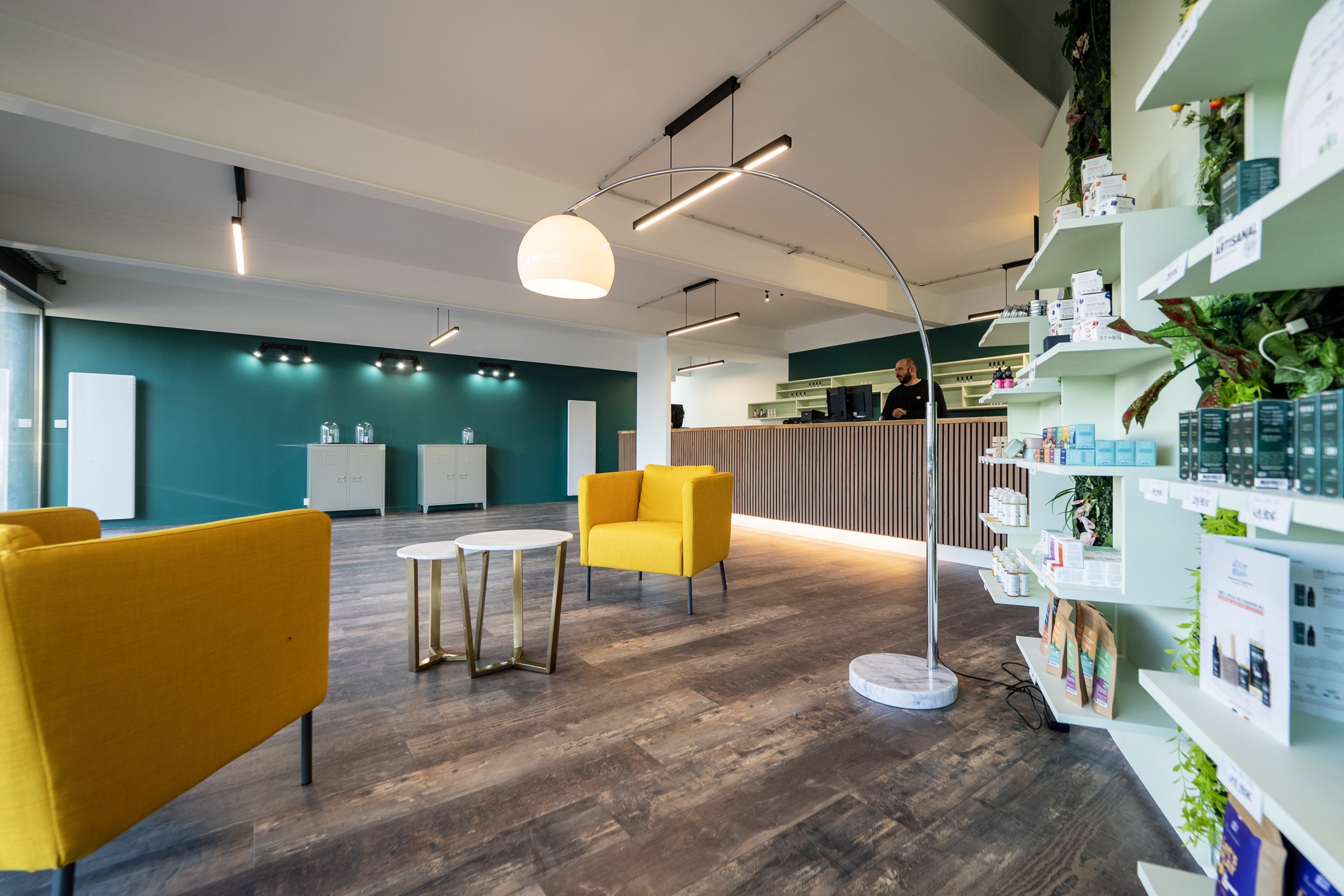 L'intérieur de la boutique Vape & Conseil : fauteuils moutarde, comptoir en bois et rayonnages d'e-liquides.